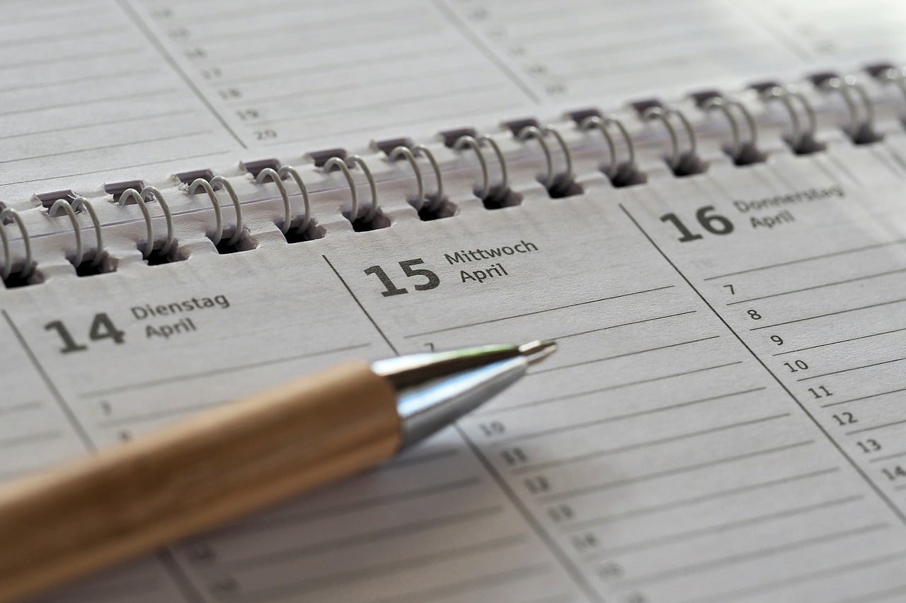 Close-up of a spiral calendar with a pen