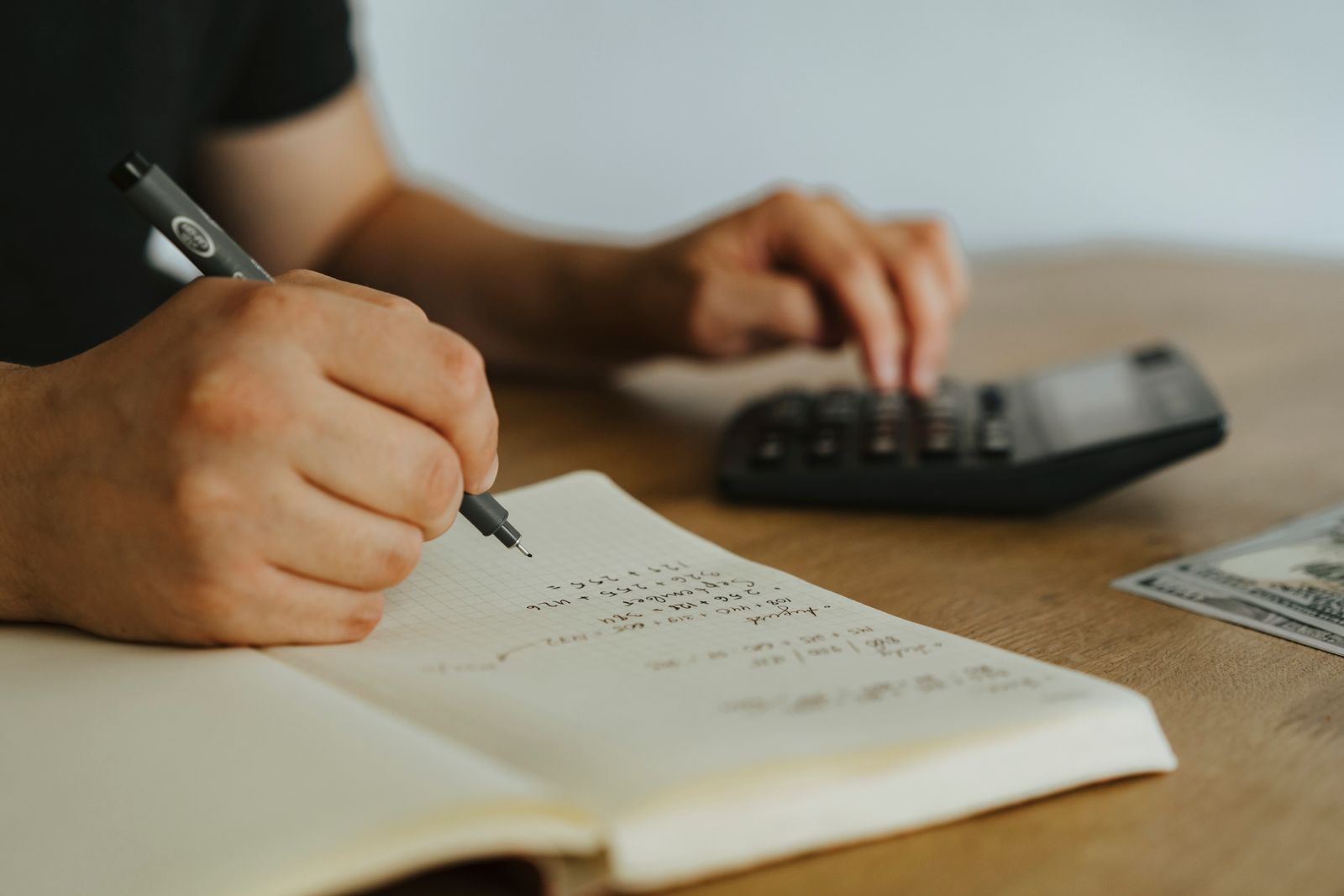 A calculator and notebook on a desk used to work out savings interest