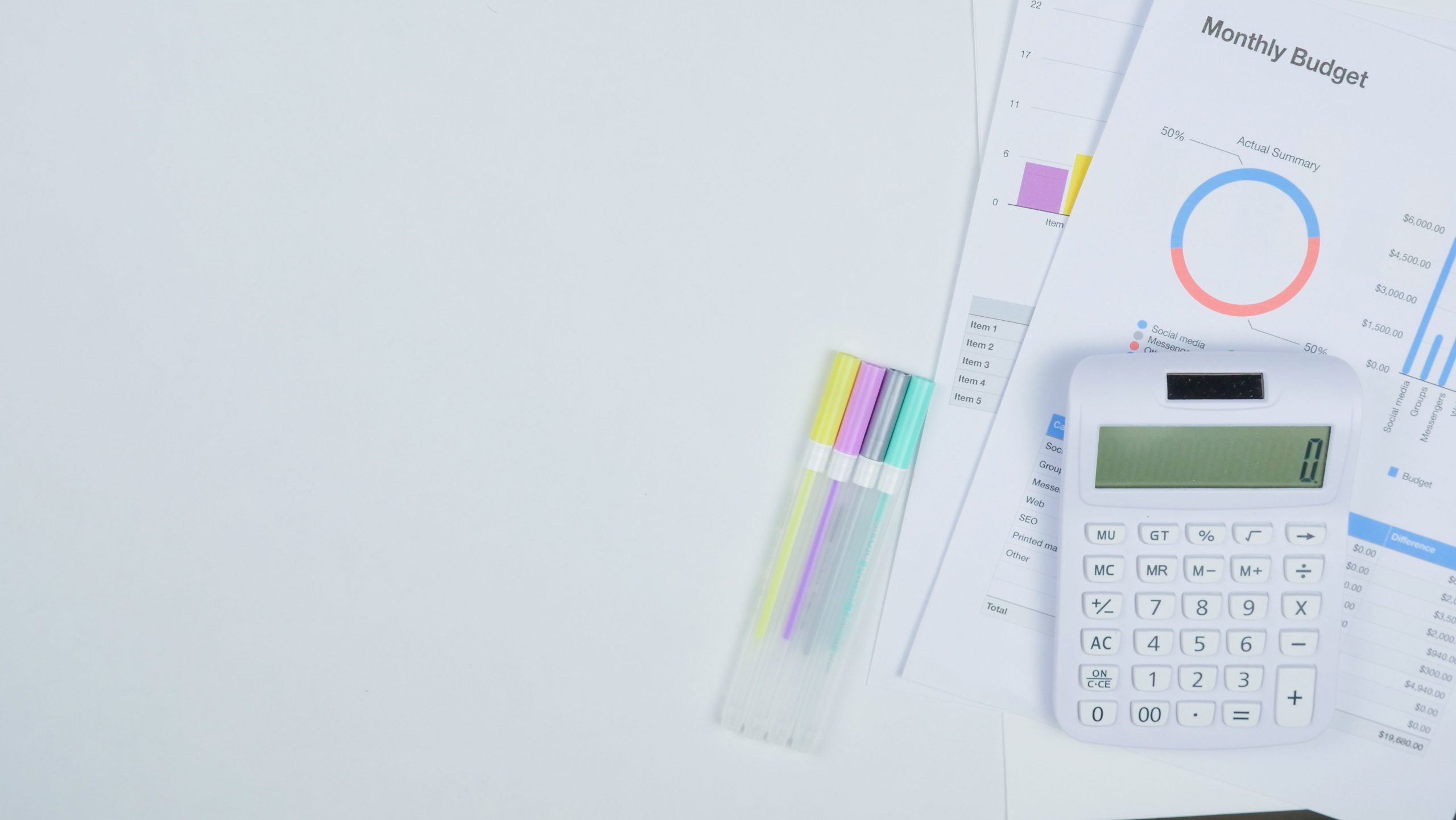 A calculator and notebook on a desk with a simple monthly savings plan